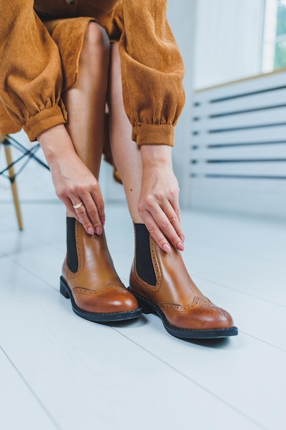 Fecho das pernas femininas em botas Chelsea de couro castanho Nova coleção de outono de sapatos de couro feminino 2022