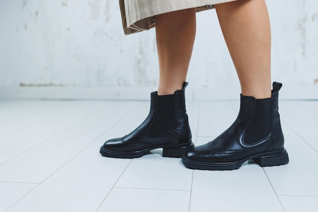 Fecho das pernas femininas em botas Chelsea de couro preto Nova coleção de outono de sapatos de couro feminino 2022