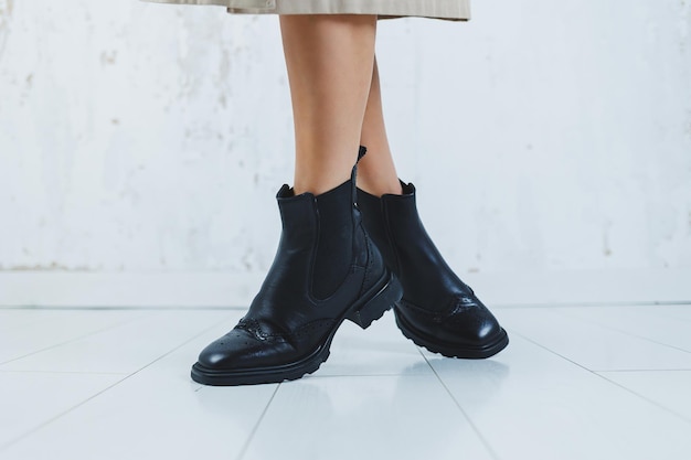 Fecho das pernas femininas em botas Chelsea de couro preto Nova coleção de outono de sapatos de couro feminino 2022