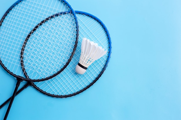 Federball- und Badmintonschläger auf blauem Hintergrund. Speicherplatz kopieren