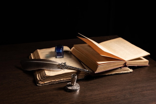 Federkiel und Tintenfass, die auf einem alten Buchkonzept für Literaturschreiber und Geschichte ruhen