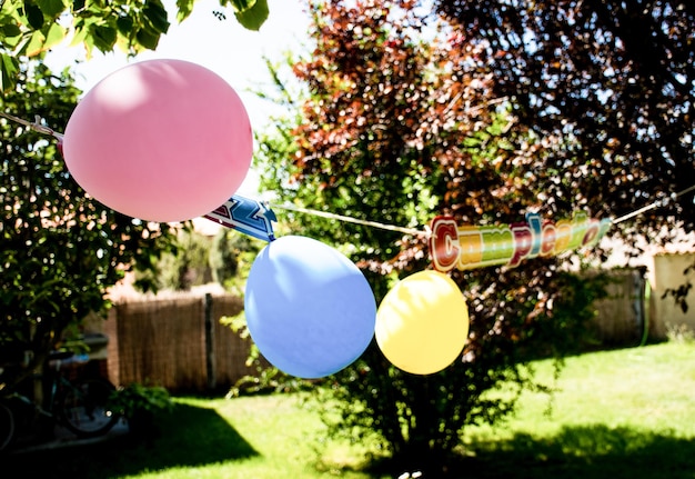 Feier einer Geburtstagsfeier für Kinder mit Luftballons im Garten eines Hauses.