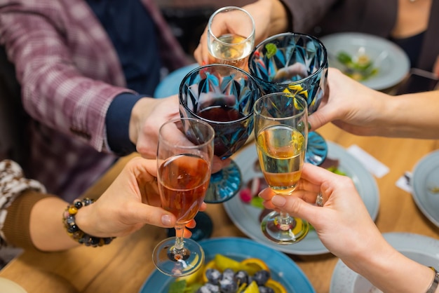 Feier. Leute, die Gläser Weißwein halten und einen Toast machen.