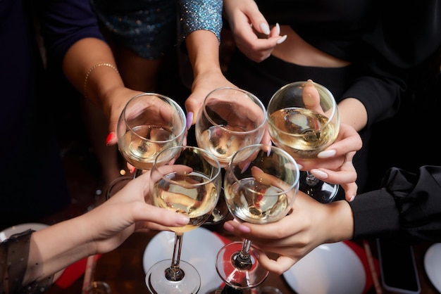 Feiern mit einem Glas Alkohol in der Hand. Fröhliche Freundinnen, die eine gute Zeit haben