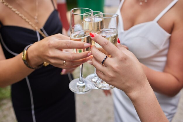 Feiern mit Gläsern Alkohol in den Händen glückliche Freundinnen, die eine gute Zeit haben