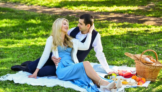 Feiern Sie die Liebe Vintage-Stil Verliebtes Paar genießt Picknickzeit und Essen im Freien Mann und Frau in der Liebe Frühlingsdatum Romantisches Datum Paar kuschelt entspannend auf der grünen Wiese mit Picknickkorb