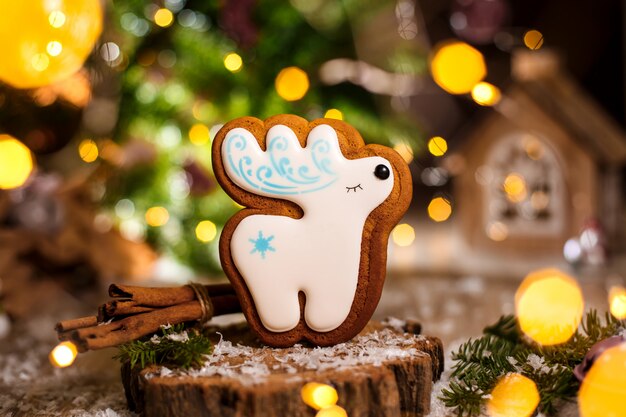 Feiertag traditionelles Essen Bäckerei. Lebkuchenweiße Weihnachtsrotwild in der gemütlichen warmen Dekoration mit Girlandenlichtern