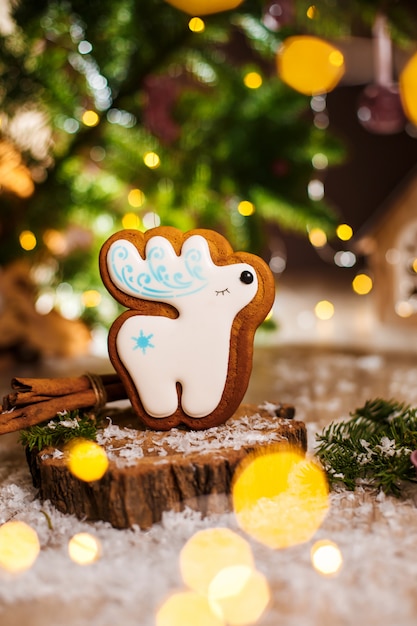 Feiertag traditionelles Essen Bäckerei. Lebkuchenweiße Weihnachtsrotwild in der gemütlichen warmen Dekoration mit Girlandenlichtern