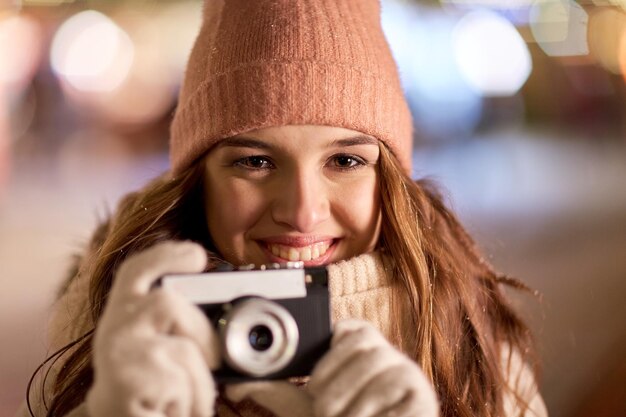 Feiertage, Fotografie und Menschen Konzept - Close-up einer schönen glücklichen jungen Frau mit Kamera zu Weihnachten