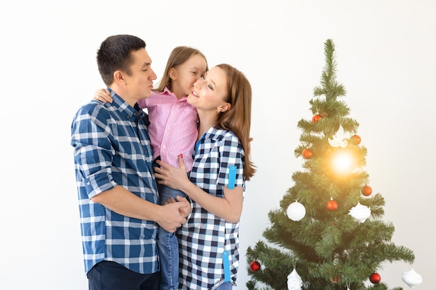 Feiertage, Geschenke und Weihnachtsbaumkonzept - Kleine Familie, die an Weihnachten eine glückliche Zeit zusammen hat