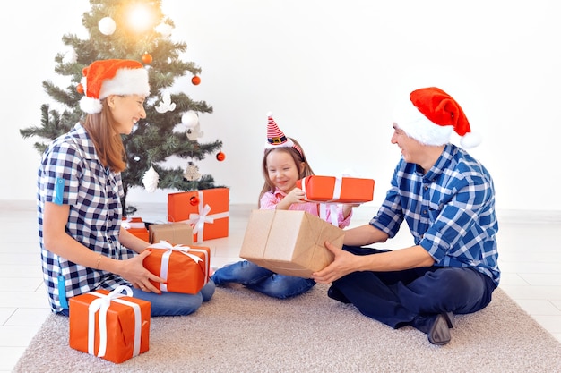 Feiertage und Geschenkkonzept - Porträt einer glücklichen Familie, die zur Weihnachtszeit Geschenke öffnet.