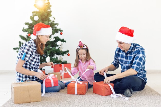 Feiertage und Geschenkkonzept - Porträt einer glücklichen Familie, die zur Weihnachtszeit Geschenke öffnet.