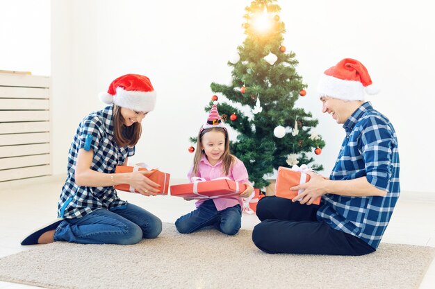 Feiertage und Geschenkkonzept - Porträt einer glücklichen Familie, die zur Weihnachtszeit Geschenke öffnet.