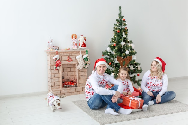 Feiertage und Geschenkkonzept - Porträt einer glücklichen Familie, die zur Weihnachtszeit Geschenke öffnet.