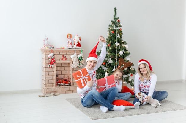 Feiertage und Geschenkkonzept - Porträt einer glücklichen Familie, die zur Weihnachtszeit Geschenke öffnet.