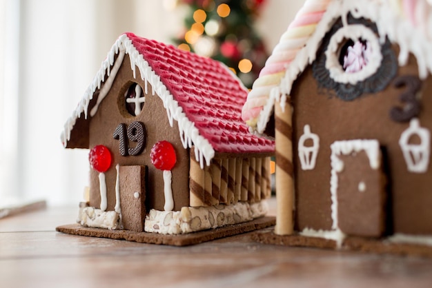 Feiertage, Weihnachten, Backen und Süßigkeiten-Konzept - Nahaufnahme von schönen Lebkuchenhäusern zu Hause