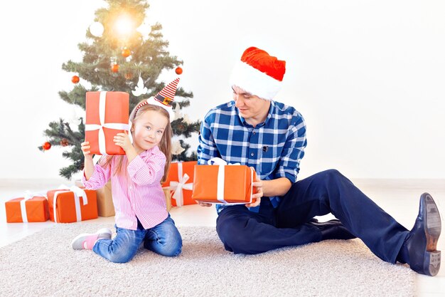 Feiertage, Weihnachten, Familie und Glückskonzept - Nahaufnahme von Vater und Tochter mit Geschenkbox