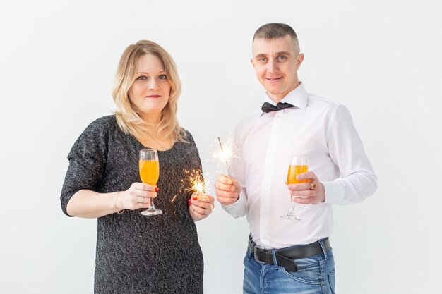 Feiertage, Weihnachten, Valentinstag und Neujahrskonzept - Frau und Mann feiern und halten Wein in einem Glas auf weißem Hintergrund.