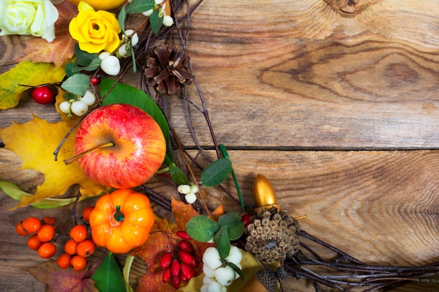 Foto feiertagshintergrund mit kürbissen, apfel, ahornblattkranz, kopienraum