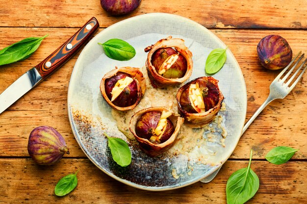 Feigen umhüllt mit gebratenem Speck, gefüllt mit Ziegenkäse.Gebackene Feigen