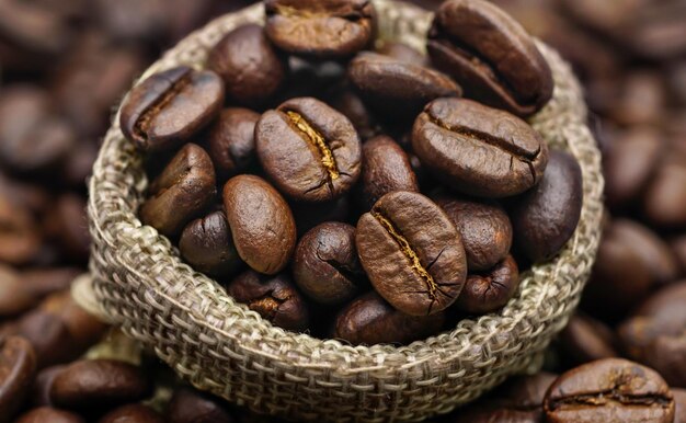 Feijão de café em saco de saco na mesa de madeira