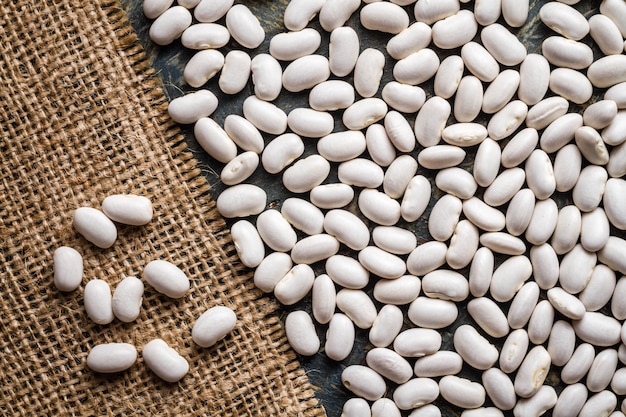 Feijão seco na mesa de madeira azul e folha de tecido de serapilheira Natural