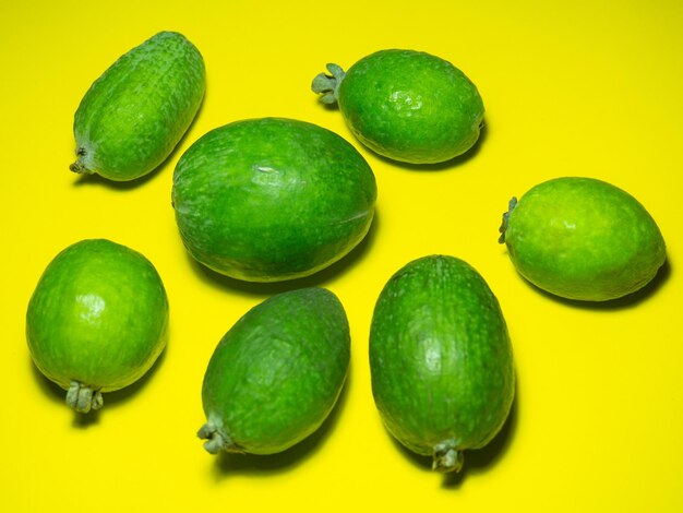 Feijoa auf gelbem Hintergrund. Grüne Früchte auf gelbem Feijoa-Hintergrund. Nützliche saure Früchte hell