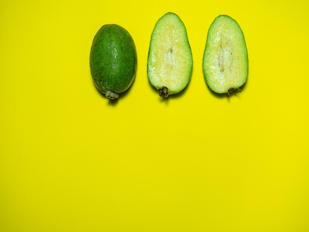 Feijoa em um fundo amarelo Frutas verdes em fundo amarelo Feijoa Frutas azedas úteis brilhantemente