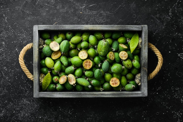 Feijoa. Frutas frescas de feijoa em uma bandeja. Vista superior, sobre um fundo de pedra preta.