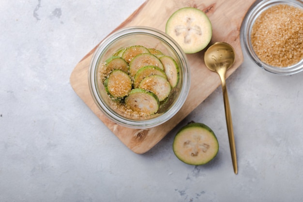 Feijoa verde à terra com açúcar em uma tábua de madeira