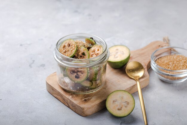 Feijoa verde molida con azúcar sobre una tabla para cortar madera