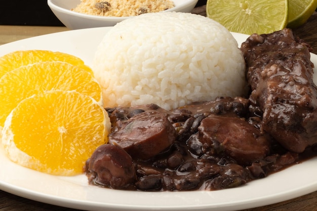 Feijoada brasileña con trozos de naranja y arroz