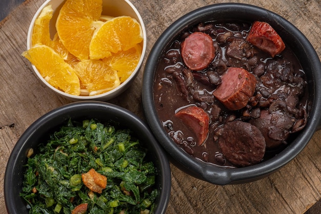 FEIJOADA typisches und traditionelles Gericht der brasilianischen Küche, serviert mit Farofa-Reis, Orangenpfeffer und Kohl