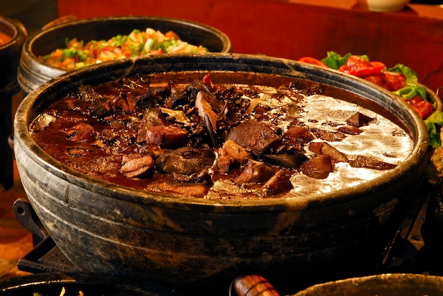 Feijoada um prato tradicional brasileiro que vai com arroz farofa couve e caipirinha