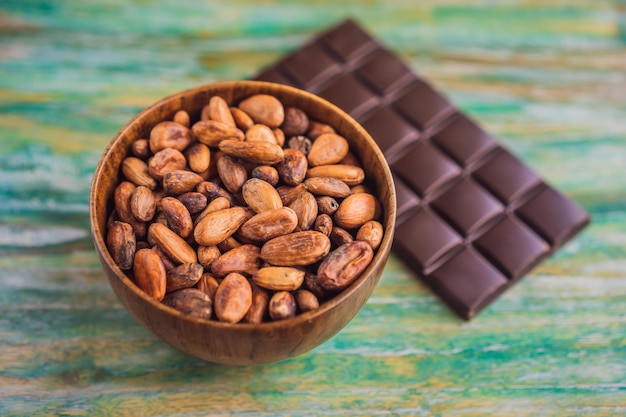 Feijões de chocolate e cacau na cor de fundo de madeira