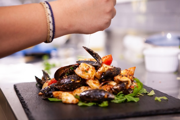 Feine Küche mit Meeresfrüchten auf schwarzem Stein in der Restaurantküche. Leckeres Essen