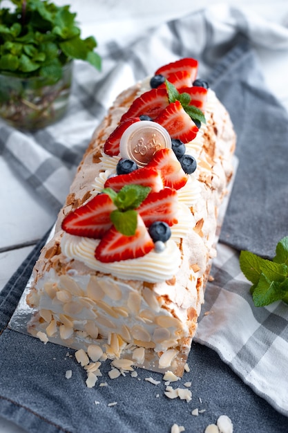 Foto feines dessert-baiser-brötchen mit erdbeeren und mandelblättern