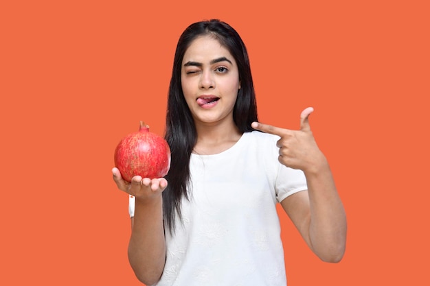 Feinschmecker Mädchen trägt weißes T-Shirt mit Granatapfel und leckt sich die Lippen indisches pakistanisches Modell