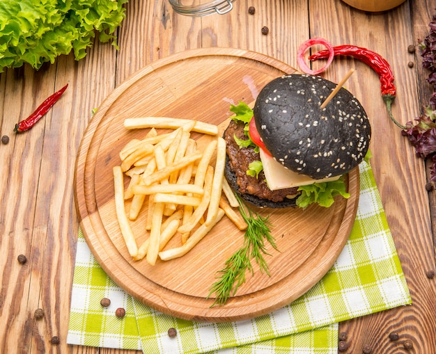 Feinschmeckerischer schwarzer Burger mit würziger Soße auf Holztisch