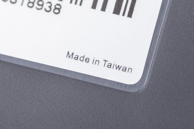 Feito em taiwan inscrição no adesivo branco do laptop preto produzindo eletrônicos no conceito de rótulo de país da ásia