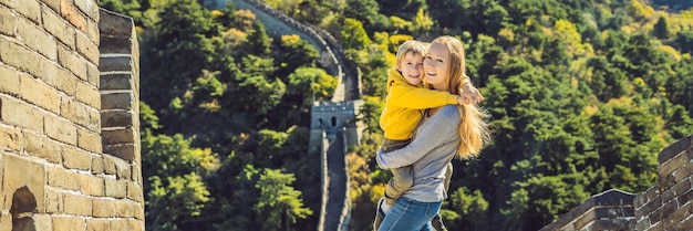 Felices alegres alegres turistas madre e hijo en la gran muralla china divirtiéndose en viajes sonriendo