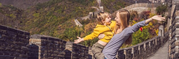 Felices alegres alegres turistas madre e hijo en la gran muralla china divirtiéndose en viajes sonriendo