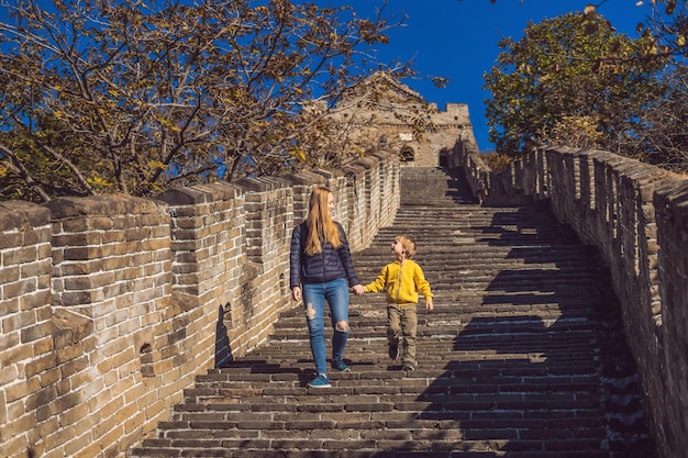 Felices alegres alegres turistas madre e hijo en la gran muralla china divirtiéndose en viajes sonriendo