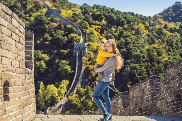 Felices alegres alegres turistas madre e hijo en la gran muralla china divirtiéndose en viajes sonriendo