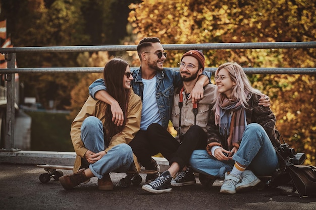 Felices y alegres amigos disfrutan del paseo otoñal en el parque de hojas doradas.