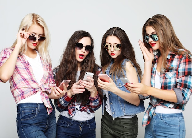 Felices amigas compartiendo redes sociales en un teléfono inteligente