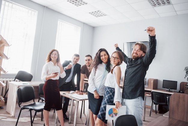 Felices colegas jóvenes sonríen y se divierten en la oficina creativa.