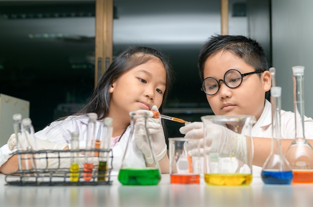 Felices dos niños haciendo experimentos científicos.