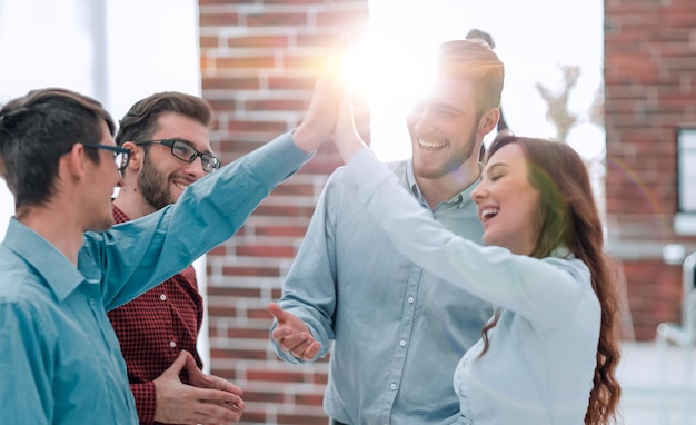 Foto felices empresarios creativos chocando los cinco en la sala de reuniones.