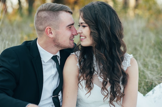 Felices y enamorados novios en el parque de otoño el día de su boda